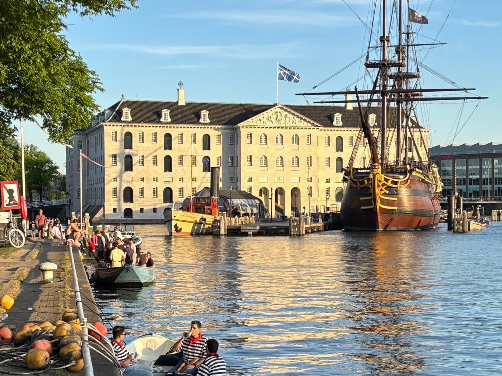 Sloops moored along the Kattenburg quay, the VOC ship and the Maritime Museum across the water