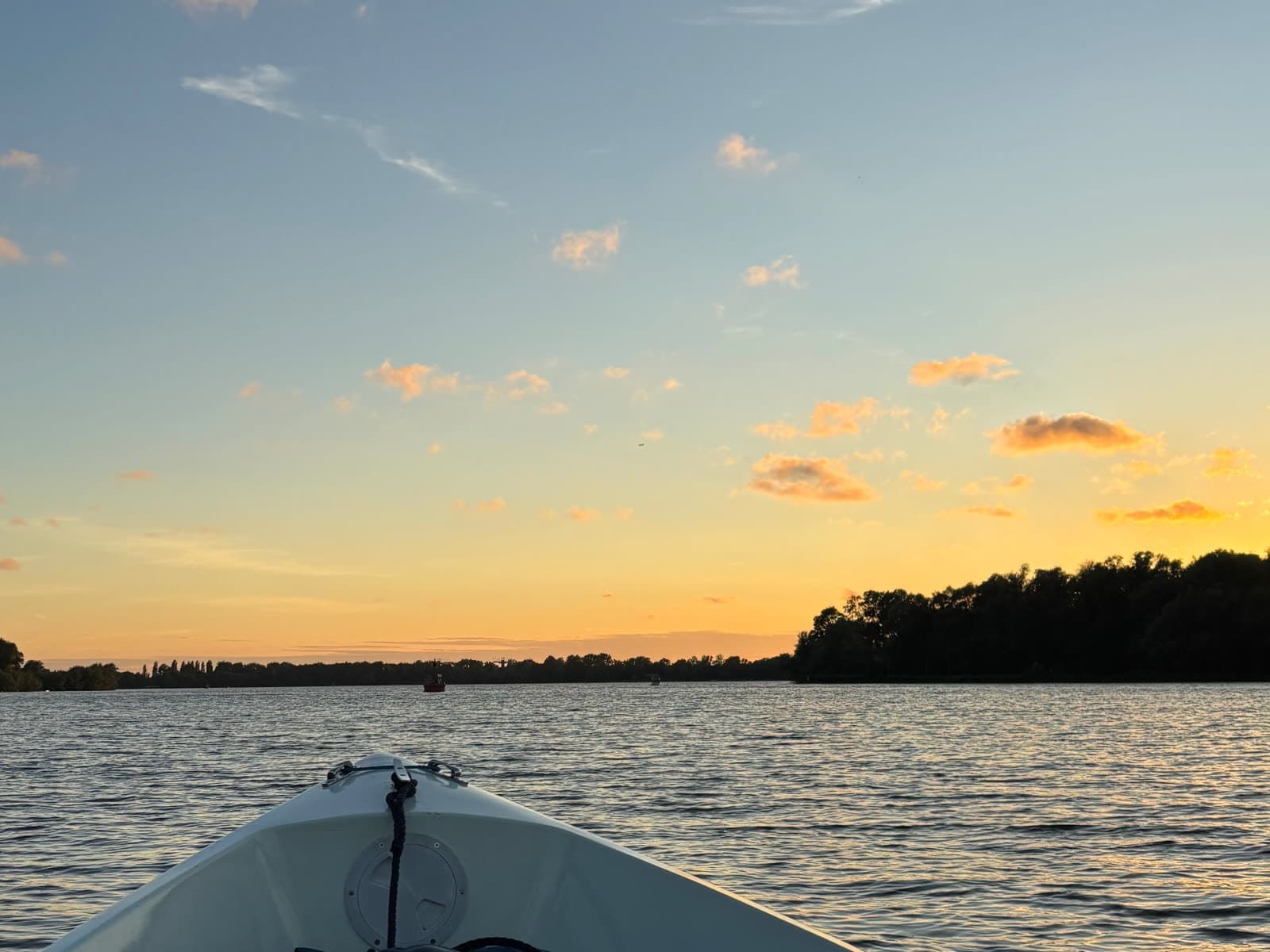 Sunset over the open water of the Nieuwe Meer, seen over the bow